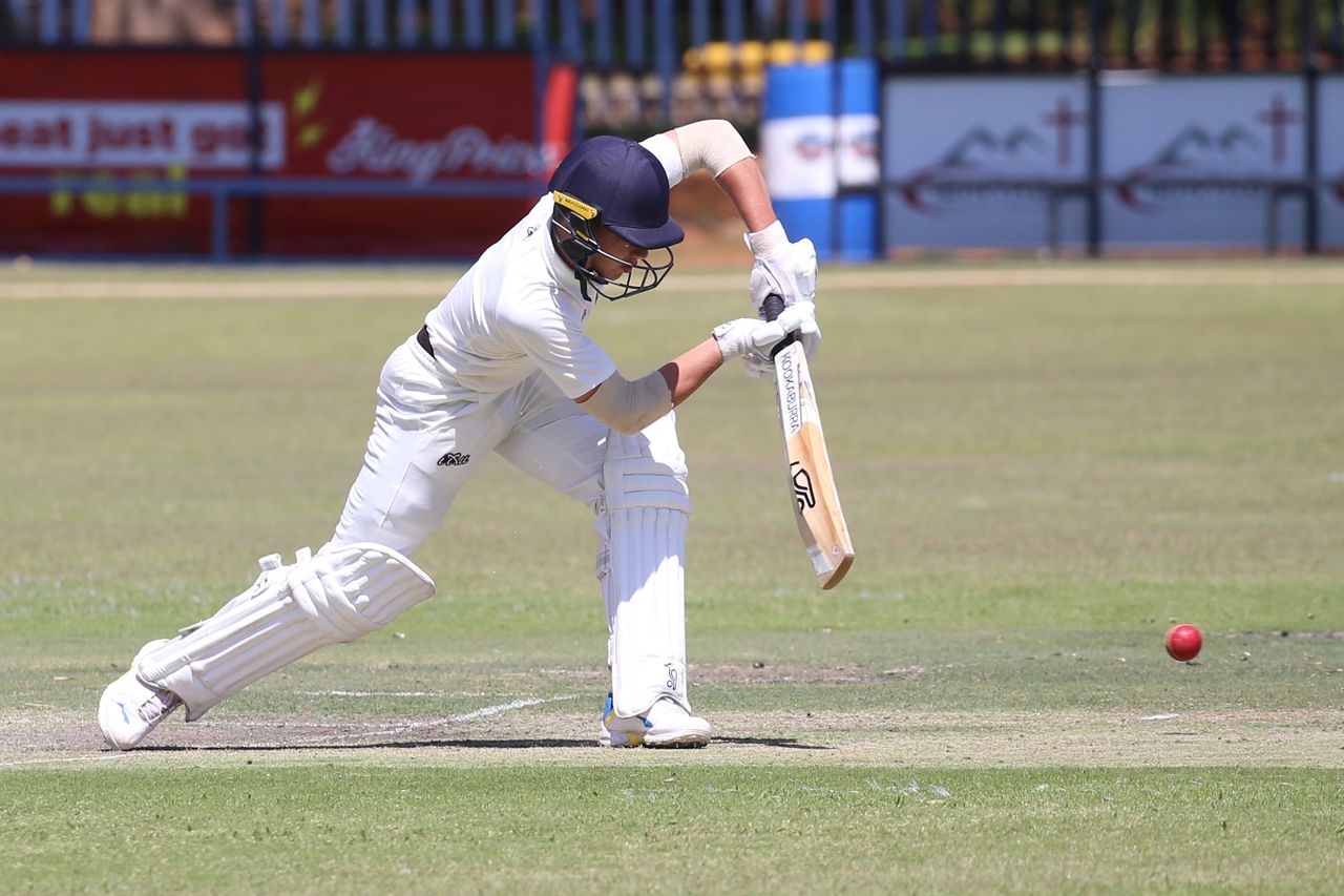 services-01 Action shot of a cricket player batting on the field during a sunny day match.